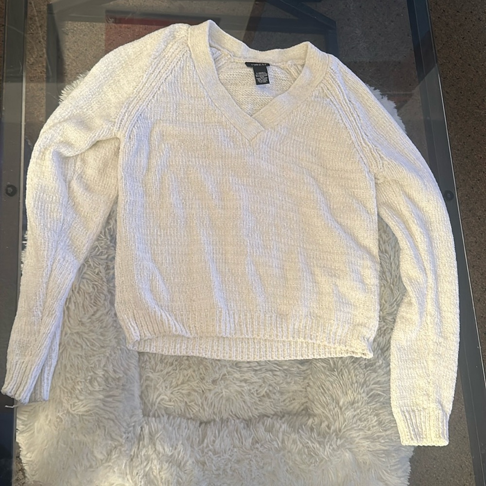 White and shiny silvery sweater. Has slits in the shoulders